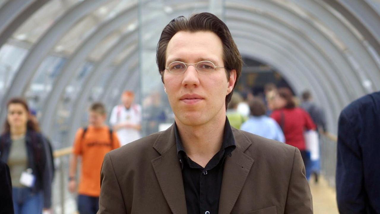 Leander Scholz in einem Gang auf der Leipziger Buchmesse. Im Hintergrund Menschen. Leander Scholz in einem Gang auf der Leipziger Buchmesse. Im Hintergrund Menschen.