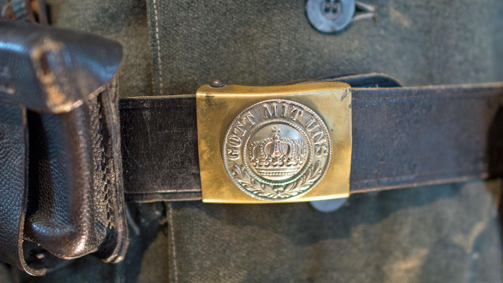 Eine Gürtelschnalle aus dem Ersten Weltkrieg mit der Aufschrift "Gott mit uns" ist am 27.06.2014 in der Ausstellung "Kriegs(er)leben im Rheinland - Zwischen Begeisterung und Verzweiflung" im LVR-Freilichtmuseum Kommern auf einem Gürtel mit Köchern an einem Armeemantel von 1915 zu sehen. Eine Gürtelschnalle aus dem Ersten Weltkrieg mit der Aufschrift "Gott mit uns" ist am 27.06.2014 in der Ausstellung "Kriegs(er)leben im Rheinland - Zwischen Begeisterung und Verzweiflung" im LVR-Freilichtmuseum Kommern auf einem Gürtel mit Köchern an einem Armeemantel von 1915 zu sehen.