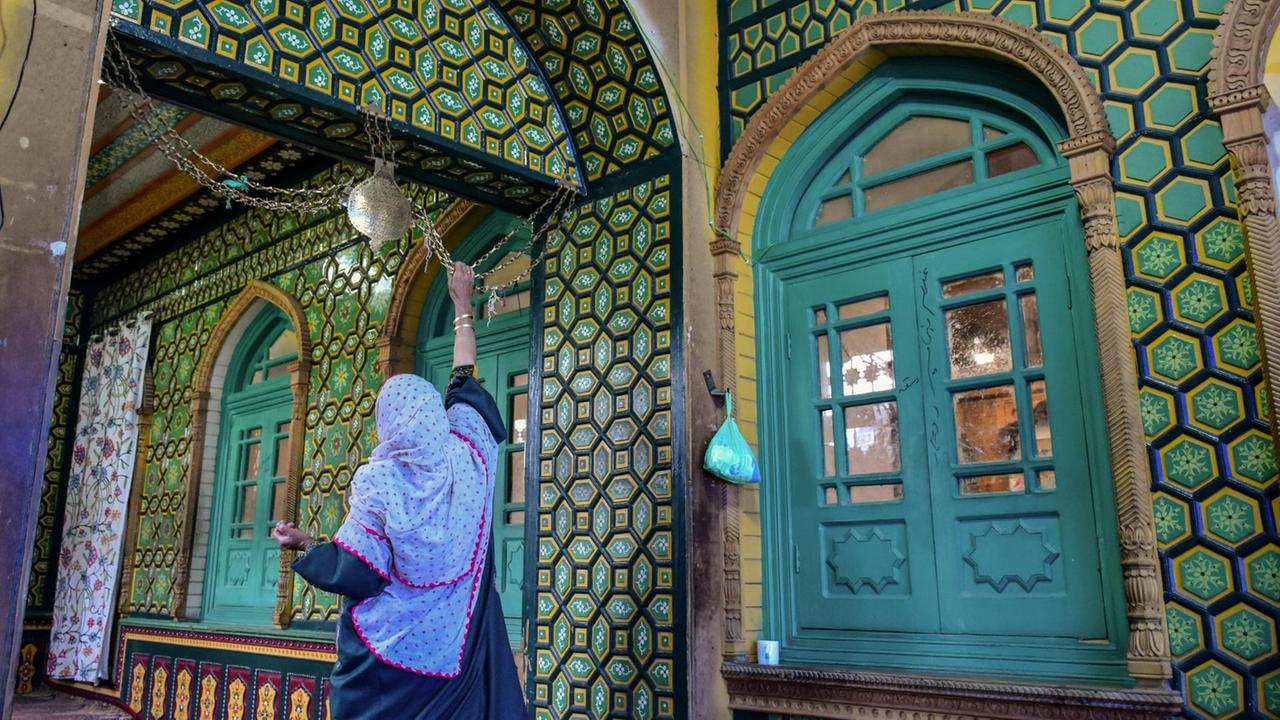 Eine Frau betet im Schrein von Syed Abdul Qadir Geelani während des ersten Tages des Ramadan. Eine Frau betet im Schrein von Syed Abdul Qadir Geelani während des ersten Tages des Ramadan.