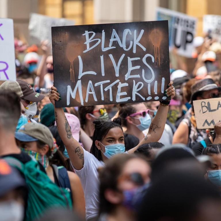 Protestierende halten Plakate mit der Aufschrift "Black Lives Matter" in die Höhe. 