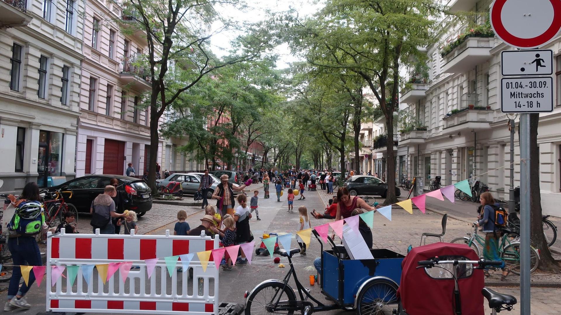 Blick auf eine gesperrte Straße, auf der viele Kinder spielen. Blick auf eine gesperrte Straße, auf der viele Kinder spielen.