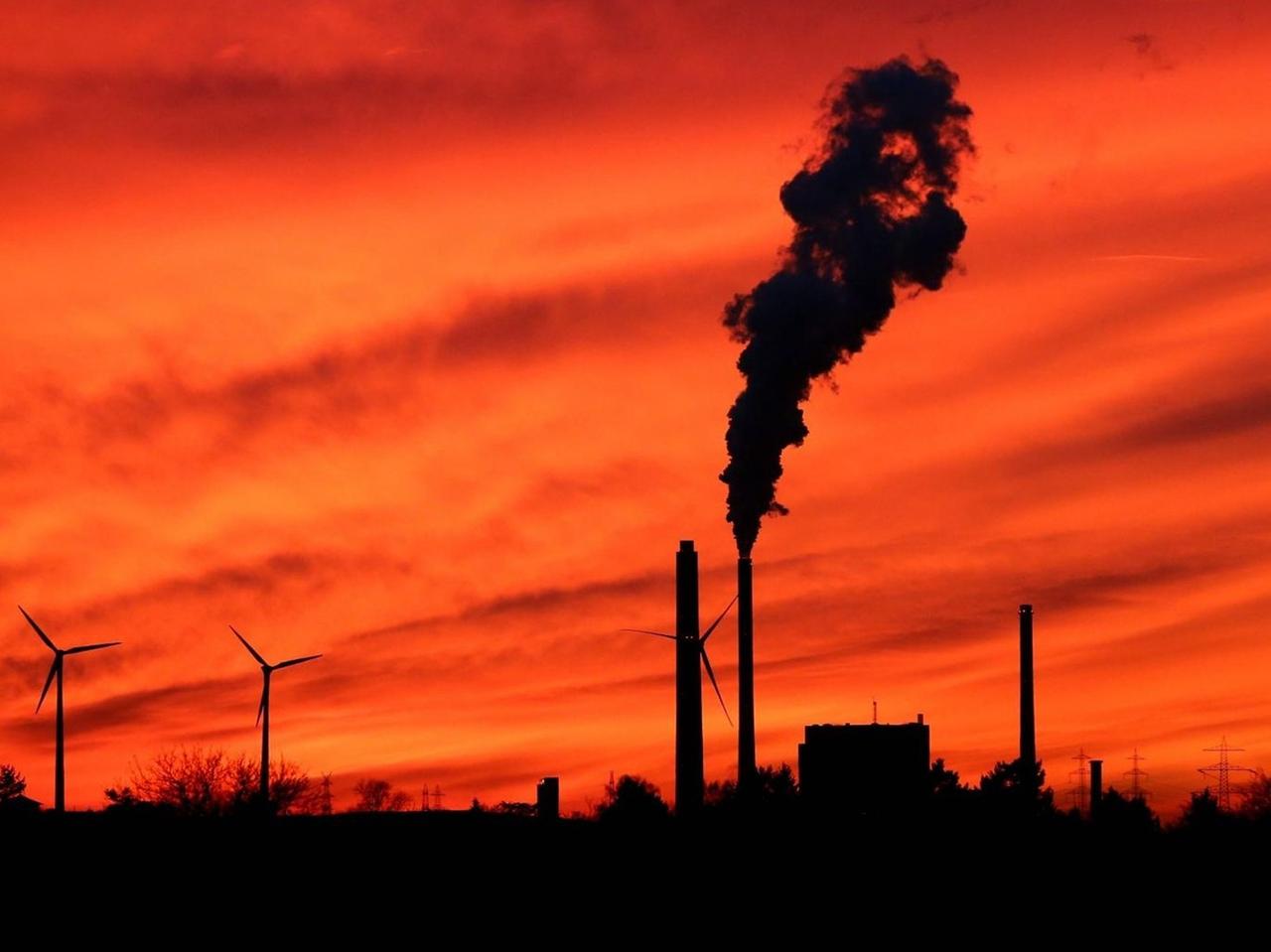 Blick in den Sonnenuntergangshimmel auf die Schornsteine des EnBW Dampfkraftwerkes und Windräder im Karlsruher Rheinhafen bei Sonnenuntergang. Blick in den Sonnenuntergangshimmel auf die Schornsteine des EnBW Dampfkraftwerkes und Windräder im Karlsruher Rheinhafen bei Sonnenuntergang.