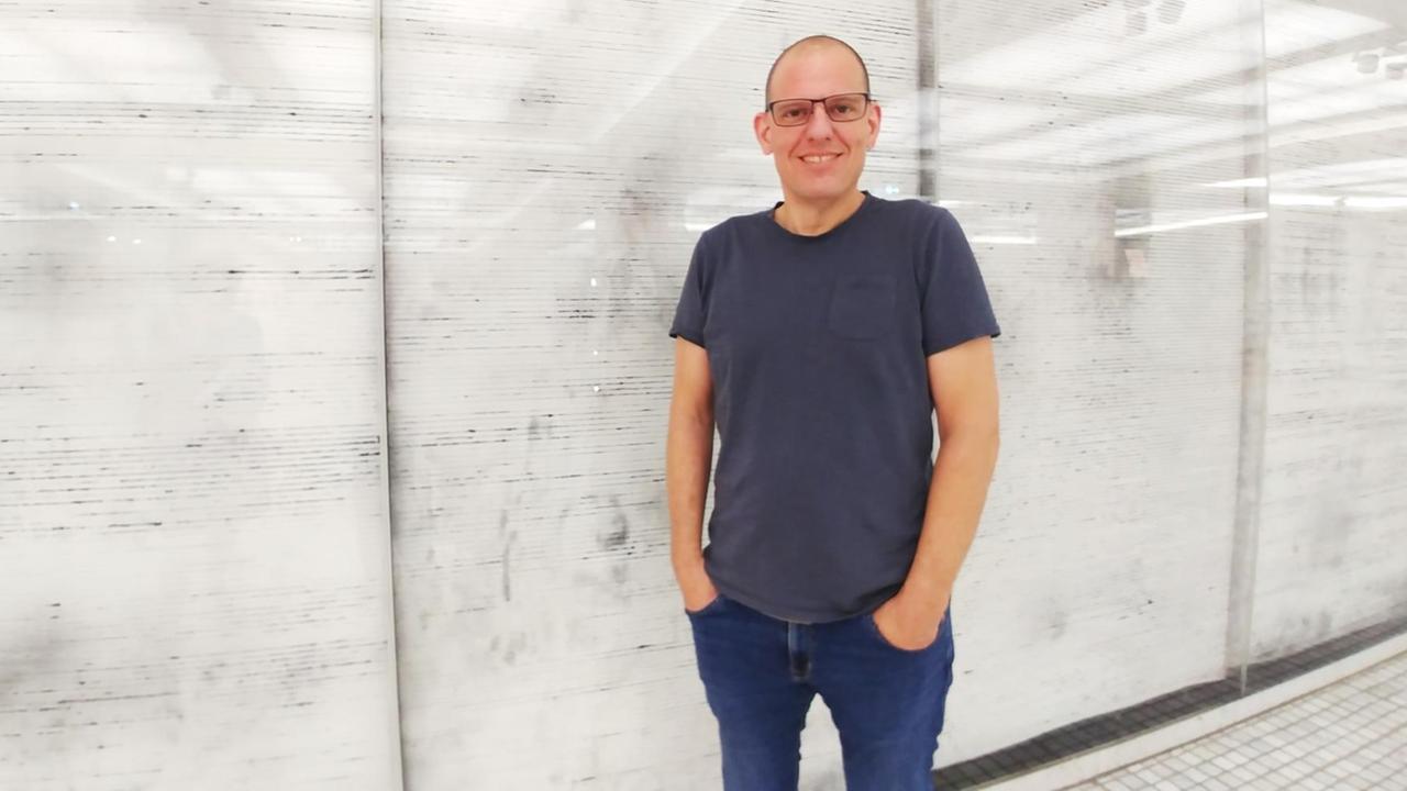 Hans Bernhard, Professor für Netz an der Kunsthochschule für Medien Köln, steht an einer Wand mit Wellenmuster im DLF-Funkhaus Hans Bernhard, Professor für Netz an der Kunsthochschule für Medien Köln, steht an einer Wand mit Wellenmuster im DLF-Funkhaus