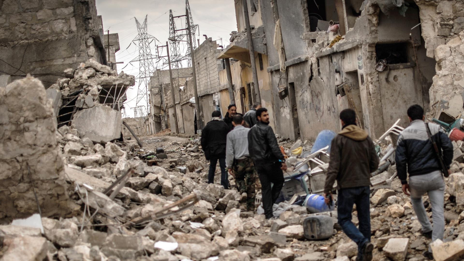 Rebellen der Freien Syrischen Armee (FSA) streifen am 07.02.2013 durch das zerstörte Sheik Saaid, einen Stadtteil von Aleppo, der ihnen als Ausgangspunkt im Kampf um eine Zementfabrik diente. Bildunterschrift Geben Sie eine individuelle Bildunterschrift e Rebellen der Freien Syrischen Armee (FSA) streifen am 07.02.2013 durch das zerstörte Sheik Saaid, einen Stadtteil von Aleppo, der ihnen als Ausgangspunkt im Kampf um eine Zementfabrik diente. Bildunterschrift Geben Sie eine individuelle Bildunterschrift e