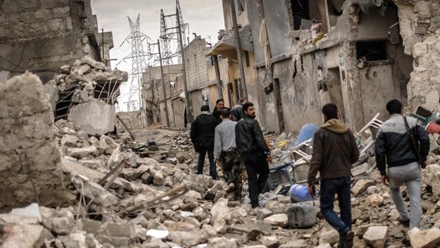 Rebellen der Freien Syrischen Armee (FSA) streifen am 07.02.2013 durch das zerstörte Sheik Saaid, einen Stadtteil von Aleppo, der ihnen als Ausgangspunkt im Kampf um eine Zementfabrik diente. Bildunterschrift Geben Sie eine individuelle Bildunterschrift e