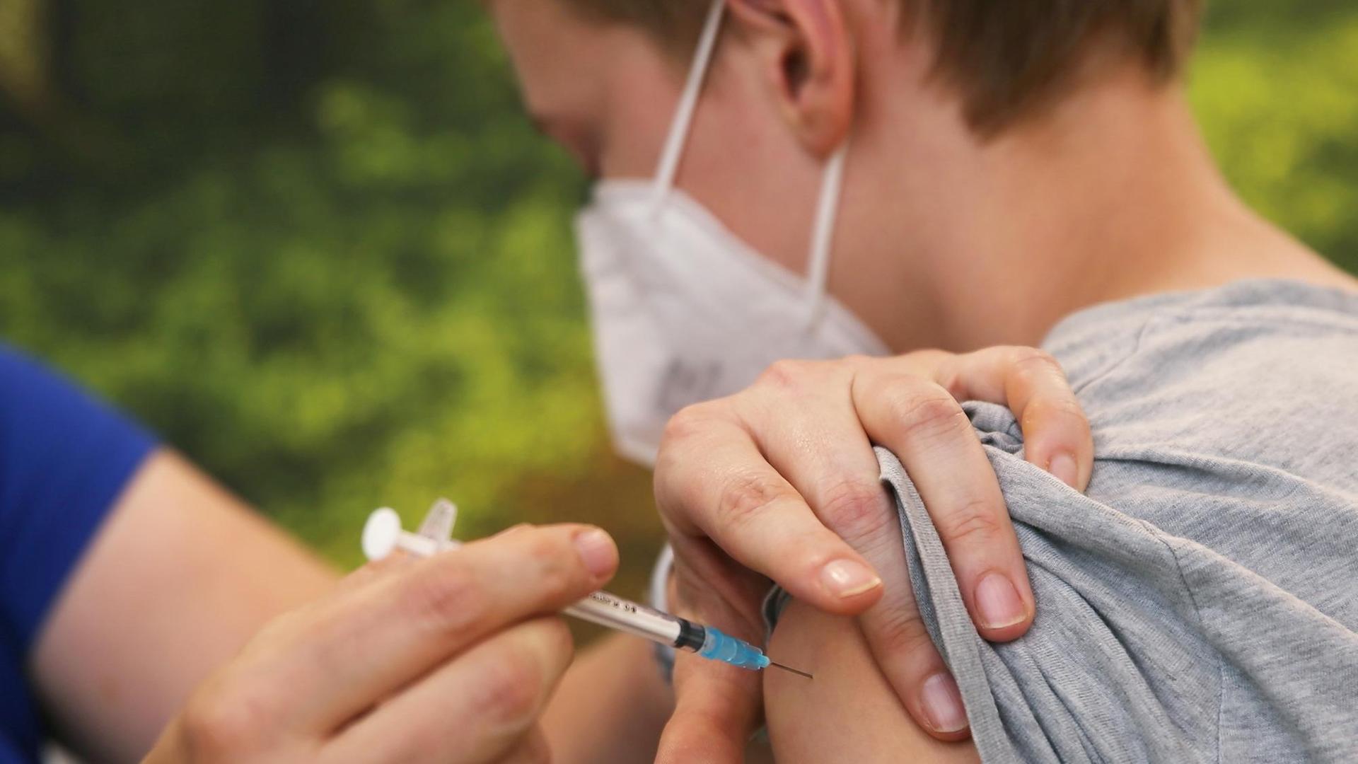 Eine Kinder-Ärztin impft einen Jungen. Eine Kinder-Ärztin impft einen Jungen.
