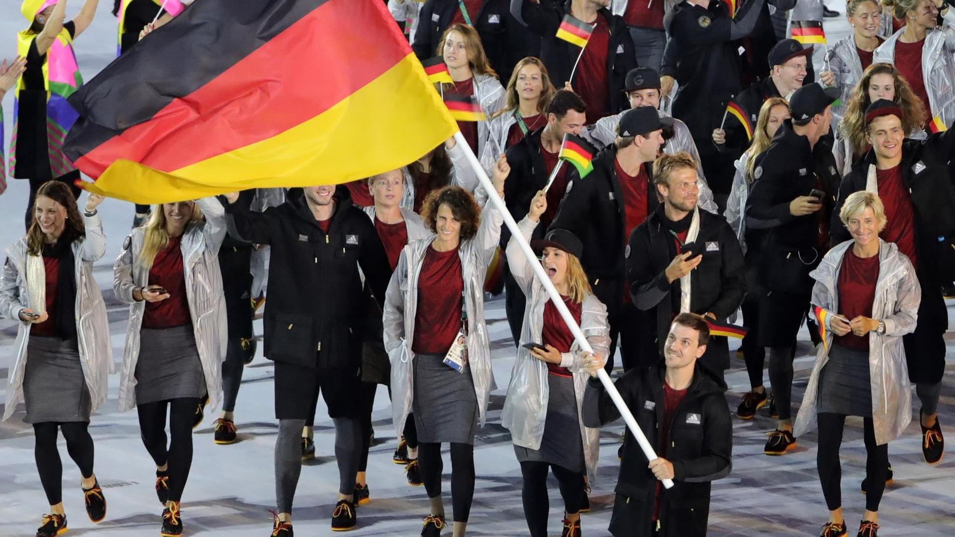 Timo Boll trägt die deutsche Fahne ins Stadion.
