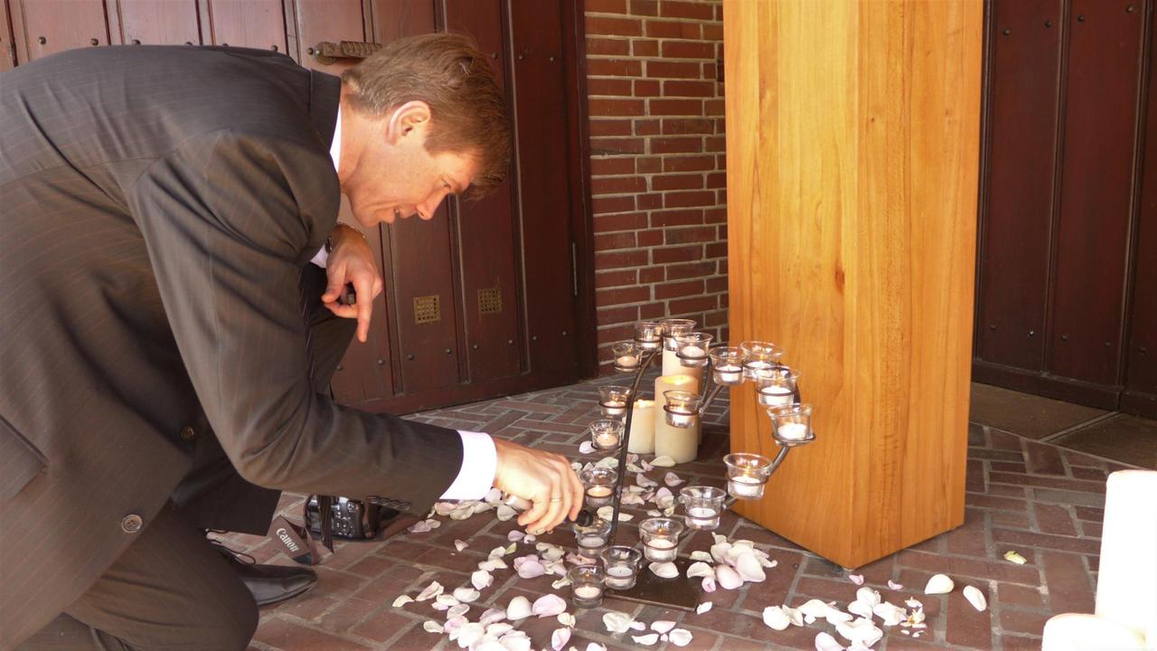 André Bade beim Dekorieren für eine Urnenbestattung auf einem Friedhof.... André Bade beim Dekorieren für eine Urnenbestattung auf einem Friedhof....