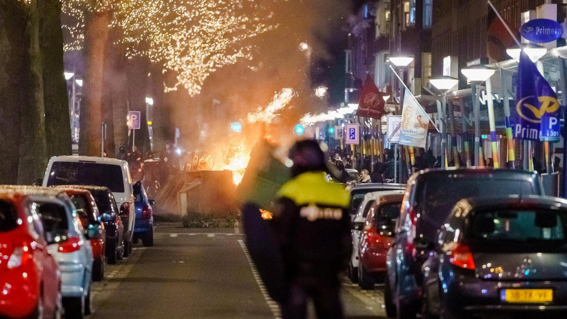 Randalierer haben eine Straße blockiert, es brennt ein Feuer. Randalierer haben eine Straße blockiert, es brennt ein Feuer.