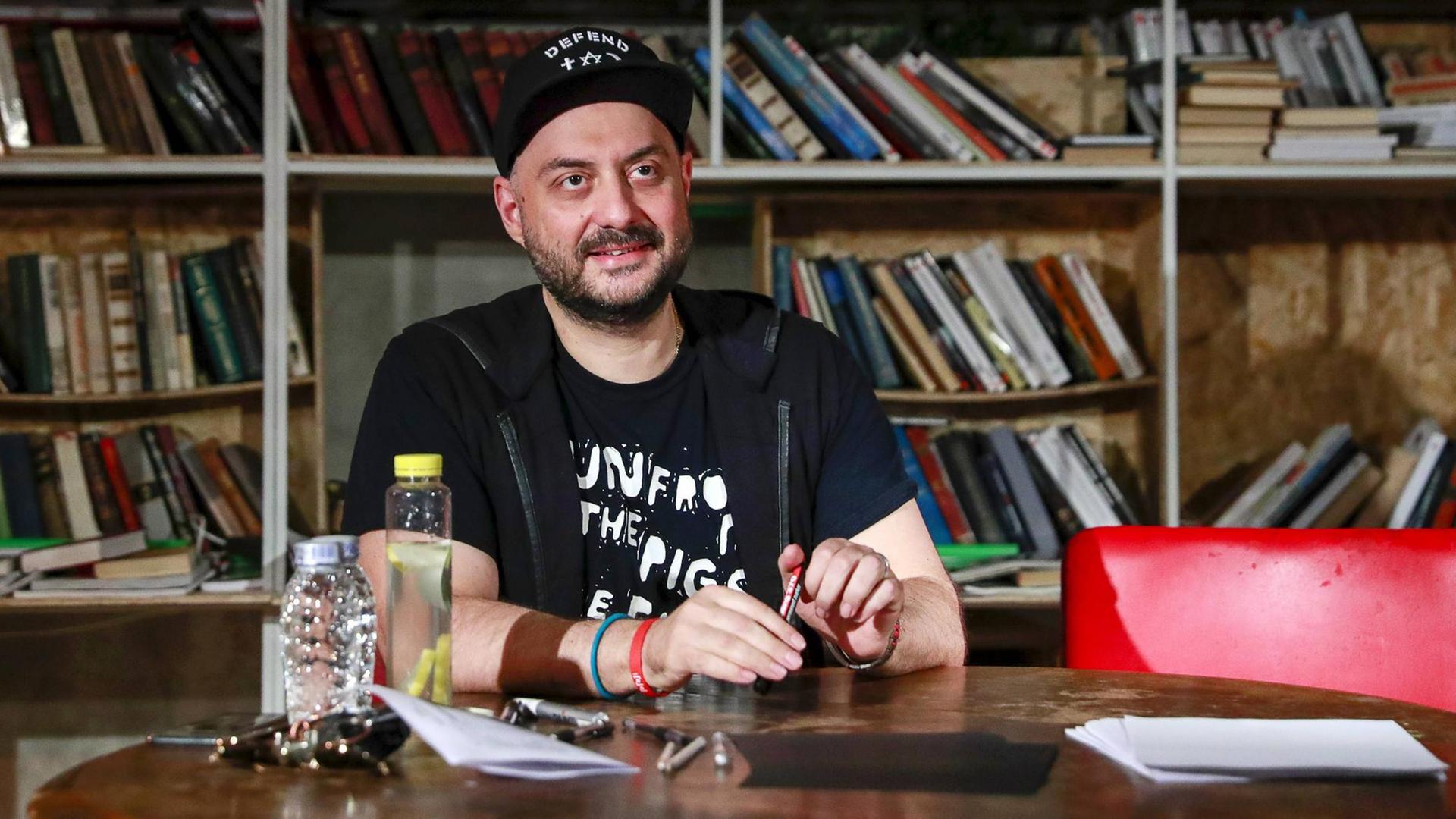 Der Regisseur Kirill Serebrennikow sitzt an einem Tisch. Der Regisseur Kirill Serebrennikow sitzt an einem Tisch.