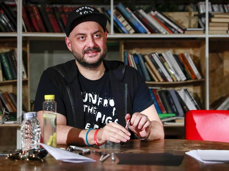 Der Regisseur Kirill Serebrennikow sitzt an einem Tisch.