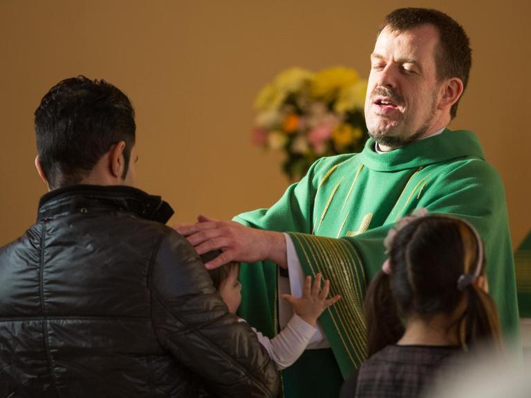 Der Pastor Gottfried Martens segnet am 08.02.2015 in der Evangelisch-Lutherischen Dreieinigkeitskirche in Berlin-Steglitz Meliza vor ihrer Taufe. Mehrere hundert Iraner und Afghanen haben sich dort in der vergangenen Jahren taufen lassen, um in das Christentum überzutreten.
