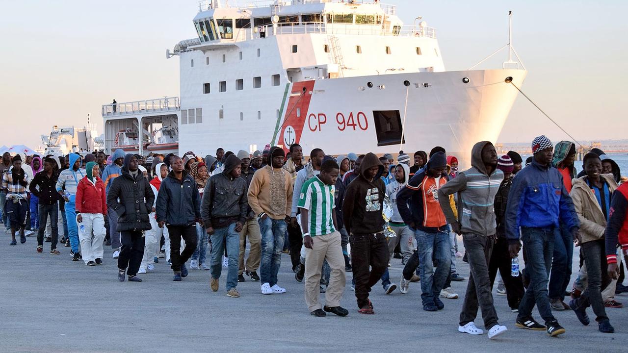 Flüchtlinge kommen auf Sizilien an, nachdem sie von der Küstenwache im Meer aufgegriffen wurden. Flüchtlinge kommen auf Sizilien an, nachdem sie von der Küstenwache im Meer aufgegriffen wurden.