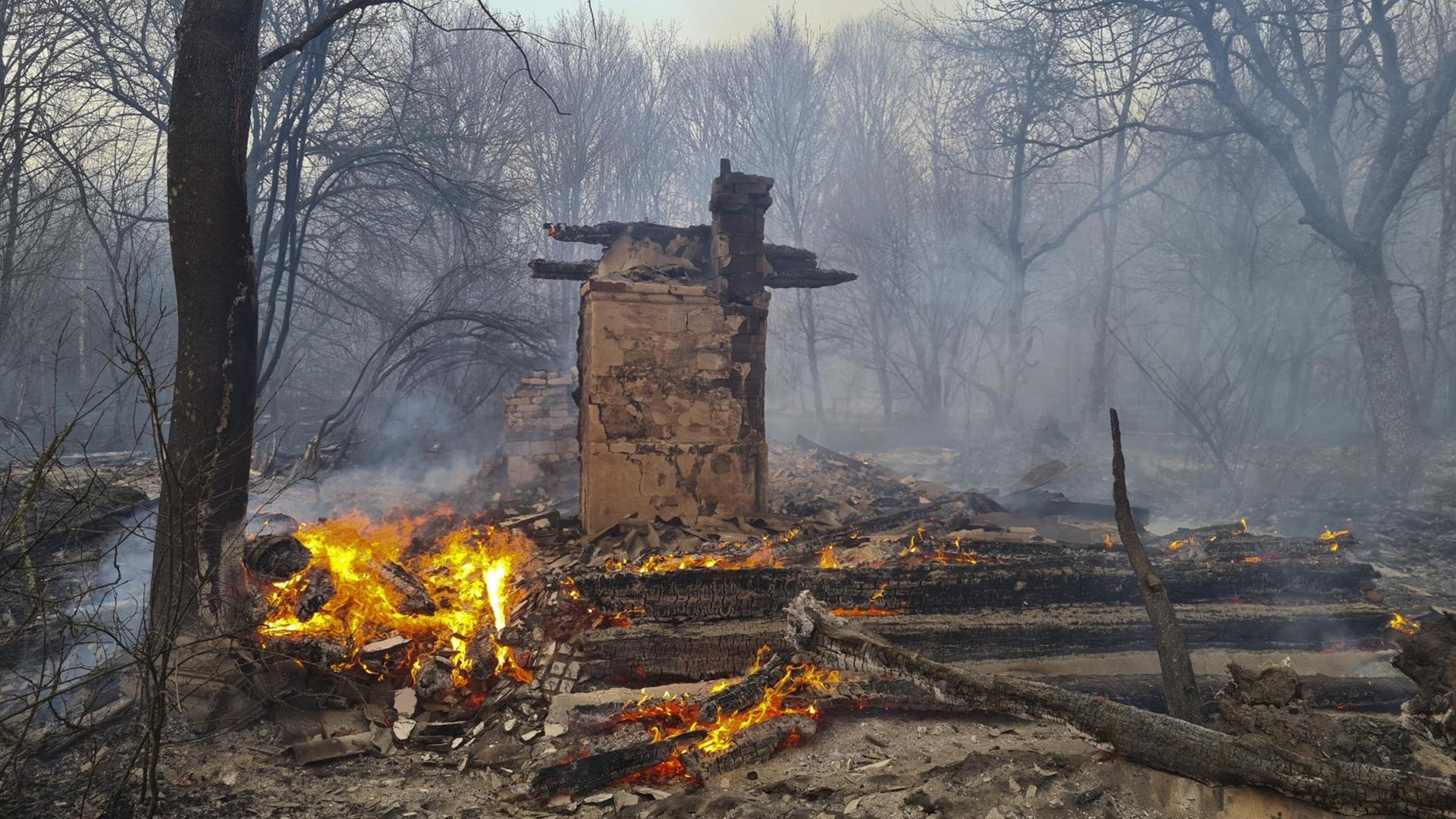 Ein Rest von einem Haus im Wald bei Tschernobyl brennt. Ein Rest von einem Haus im Wald bei Tschernobyl brennt.