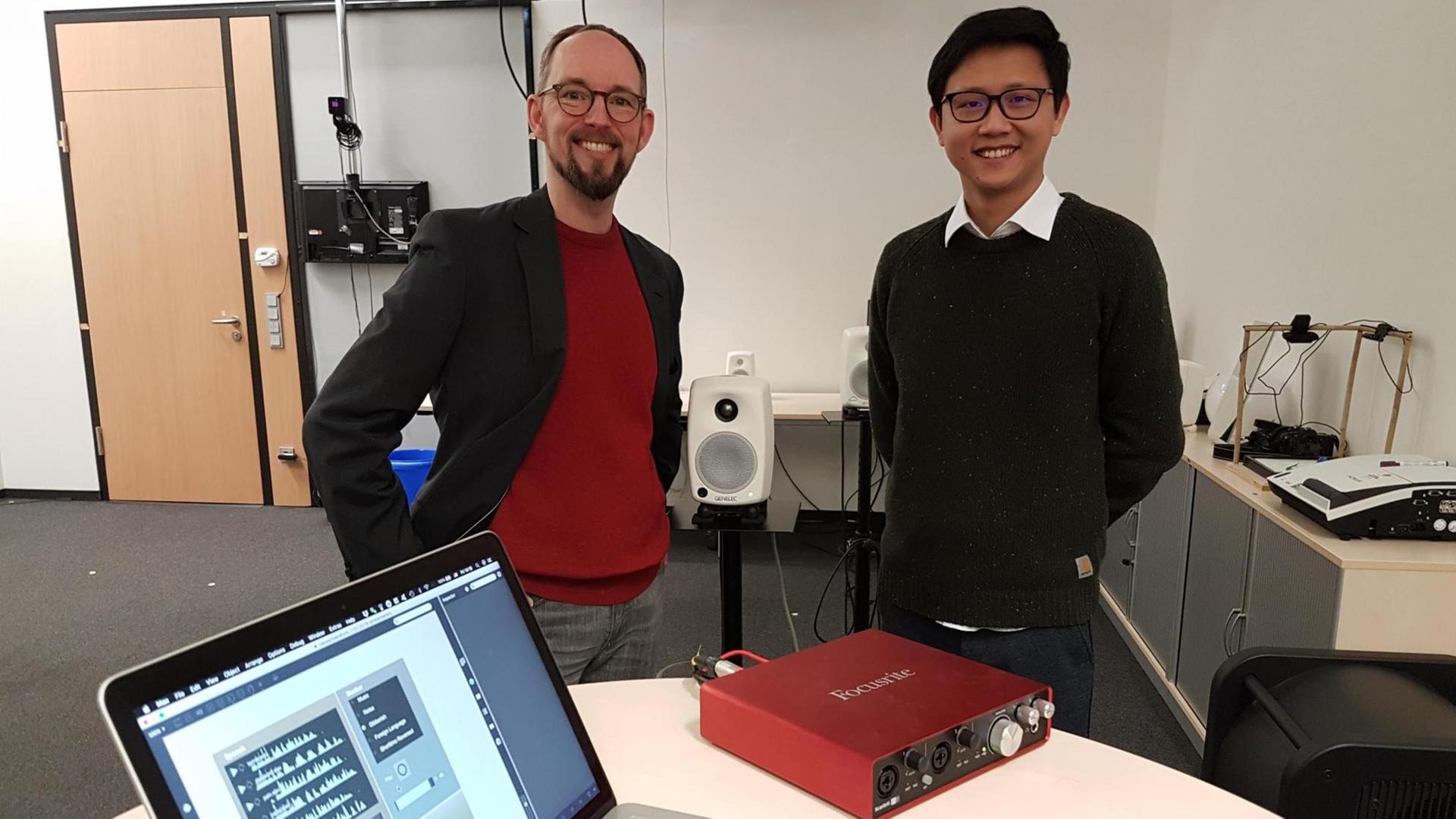 Die Bielefelder Forscher Thomas Hermann und Jiajun Yang stehen nebeneinander in der Mitte eines Arbeitsraumes, im Vordergrund ein Tisch mit einem aufgeklappten Laptop Die Bielefelder Forscher Thomas Hermann und Jiajun Yang stehen nebeneinander in der Mitte eines Arbeitsraumes, im Vordergrund ein Tisch mit einem aufgeklappten Laptop