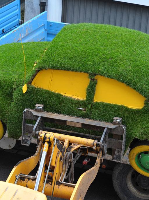 Ein mit Rollrasen überzogener VW Käfer wird für die Gartenmesse in Bamberg abgeladen.