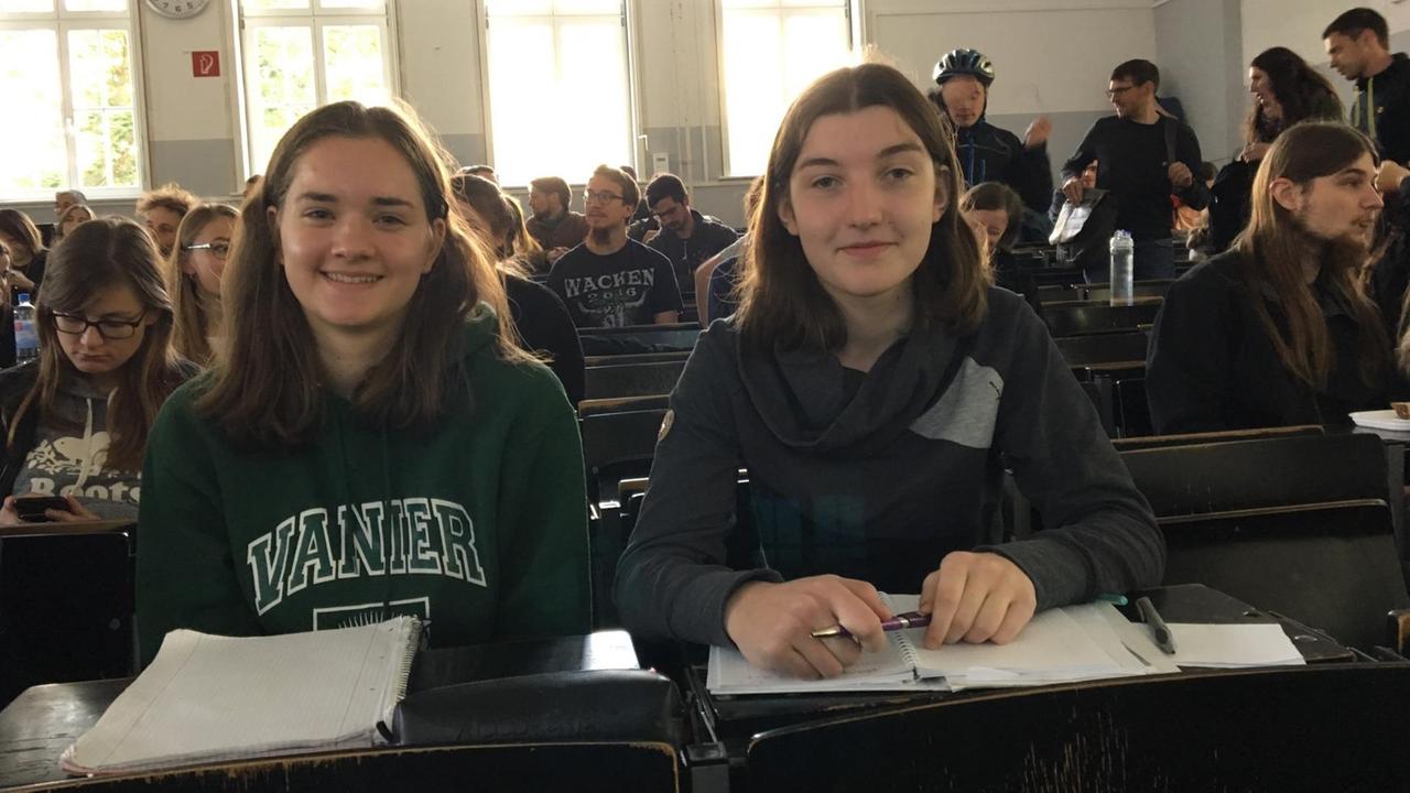 Marie und Katharina sitzen in einem Vorlesungssaal. Marie und Katharina sitzen in einem Vorlesungssaal.
