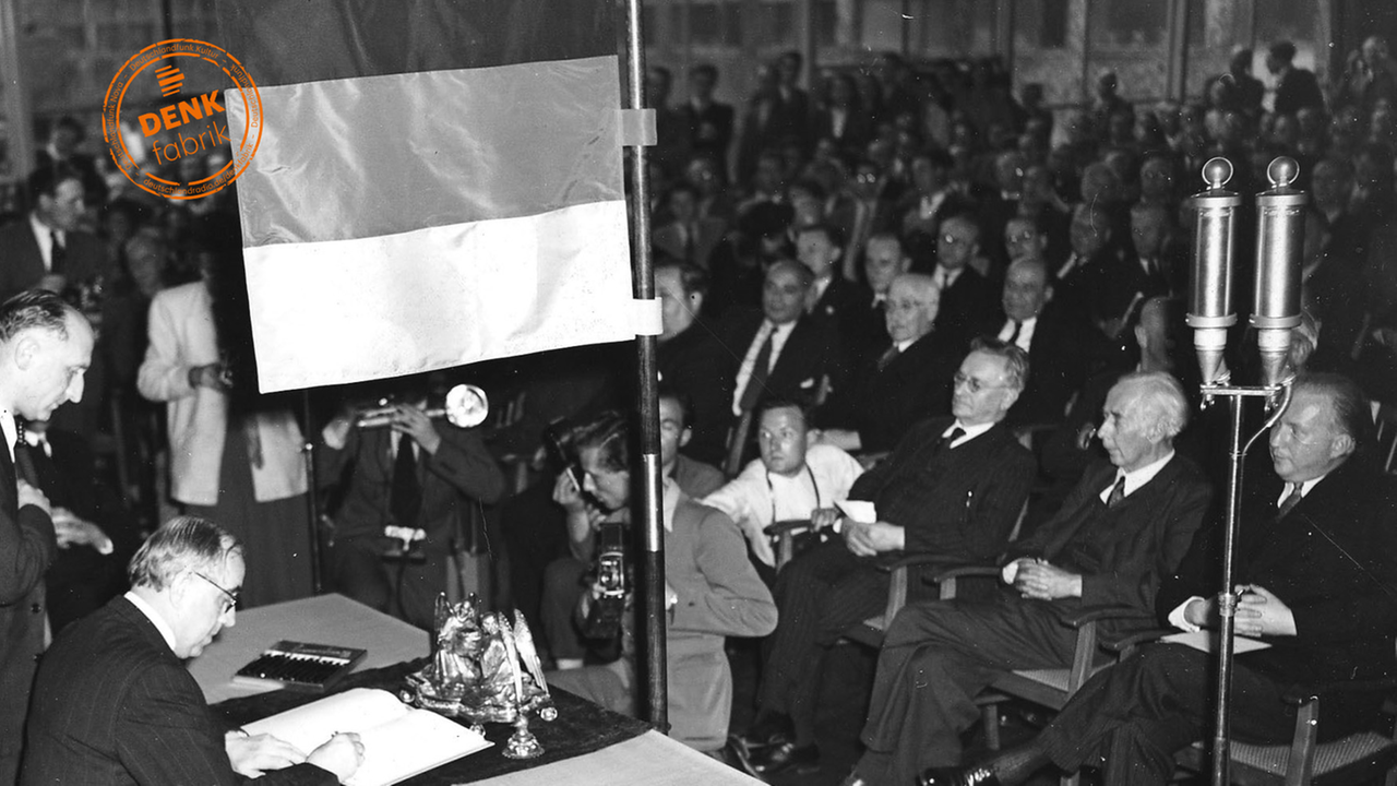 Prof. Ernst Reuter, Oberbürgermeister und Abgeordneter im parlamentarischen Rat der Stadt Berlin, bei der Unterzeichnung des Grundgesetzes. In der ersten Reihe von rechts nach links: Dr. Hans Christoph Seebohm, Minister a. D. (DP Niedersachsen), Prof. Theodor Heuss (FDP Baden-Württemberg) und Paul Loebe, Reichstagspräsident a. D. (SPD Berlin). Prof. Ernst Reuter, Oberbürgermeister und Abgeordneter im parlamentarischen Rat der Stadt Berlin, bei der Unterzeichnung des Grundgesetzes. In der ersten Reihe von rechts nach links: Dr. Hans Christoph Seebohm, Minister a. D. (DP Niedersachsen), Prof. Theodor Heuss (FDP Baden-Württemberg) und Paul Loebe, Reichstagspräsident a. D. (SPD Berlin).