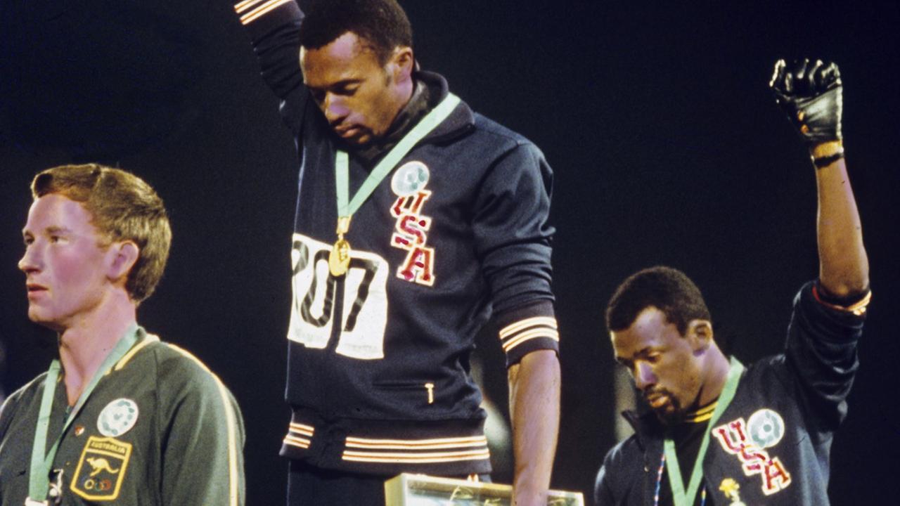 Bei der Siegerehrung für den 200m-Lauf der Männer demonstrieren die Amerikaner Tommie Smith (M, Goldmedaille) und John Carlos (r, Bronzemedaille) mit hochgereckter geballter Faust in schwarzem Handschuh für die "Black Power" Bewegung. Links der Gewinner der Silbermedaille, der Australier Peter Norman. Bei der Siegerehrung für den 200m-Lauf der Männer demonstrieren die Amerikaner Tommie Smith (M, Goldmedaille) und John Carlos (r, Bronzemedaille) mit hochgereckter geballter Faust in schwarzem Handschuh für die "Black Power" Bewegung. Links der Gewinner der Silbermedaille, der Australier Peter Norman.
