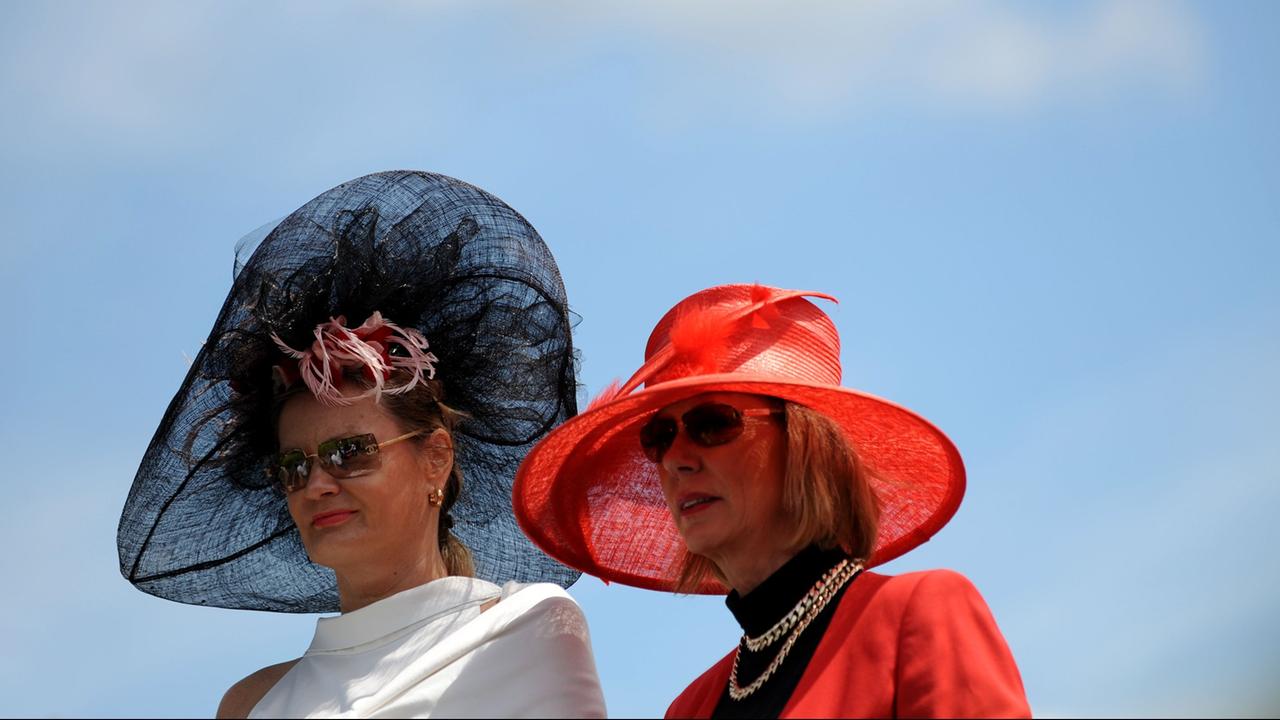Zwei Damen mit auffälligen Hüten. 
