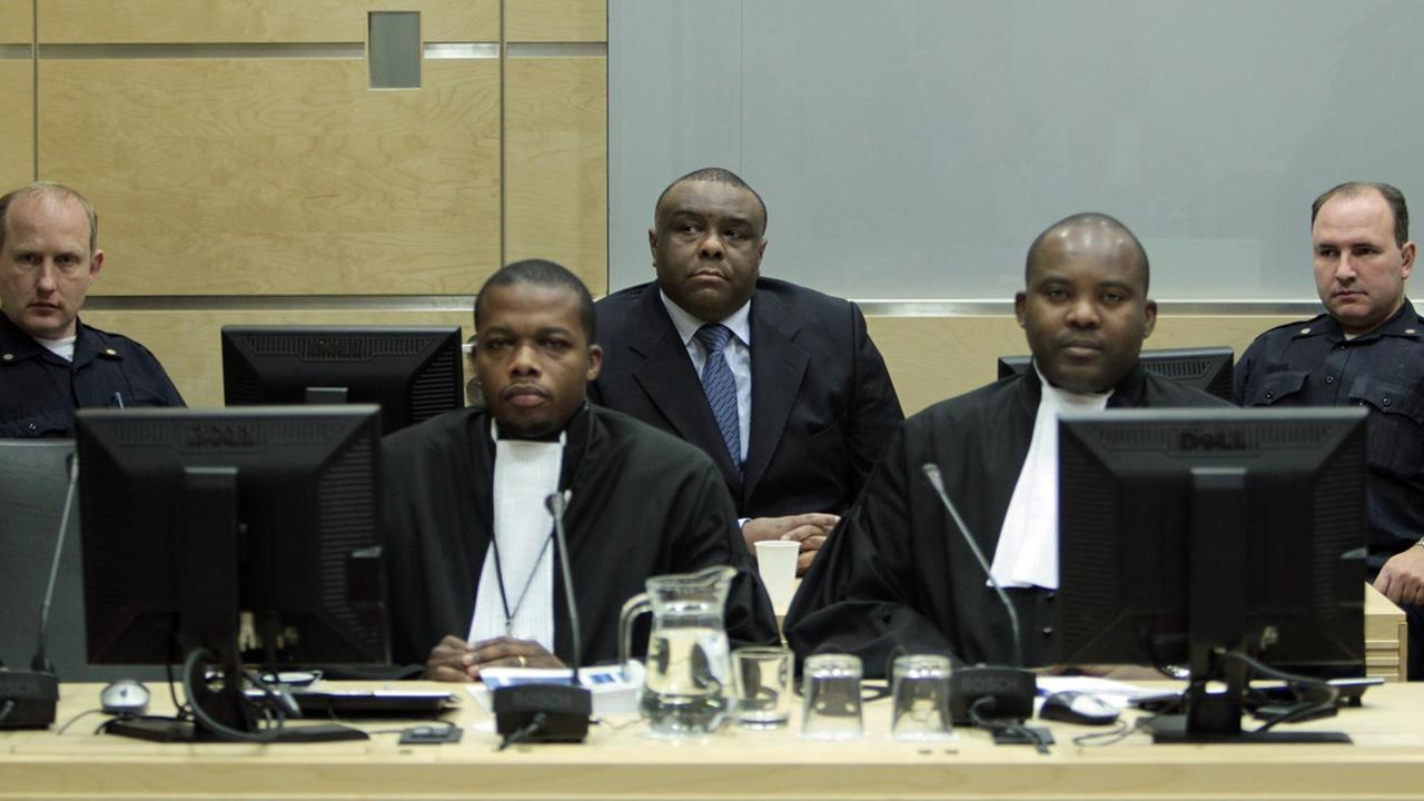 Der frühere kongolesische Vizepräsident Jean-Pierre Bemba mit Anwalt und Justizbediensteten auf der Anklagebank im Internationalen Strafgerichtshof in Den Haag (2010).
