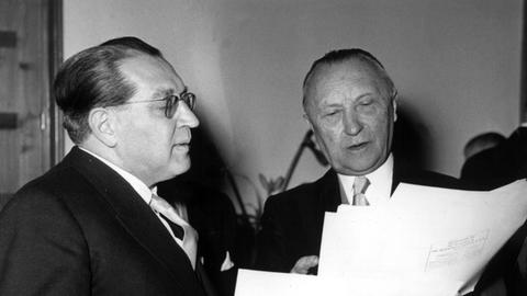 Zusammen mit Thomas Dehler studiert Bundeskanzler Konrad Adenauer Glückwunsch-Telegramme, die Adenauer zu seinem 79. Geburtstag am 5.1.1955 aus aller Welt erreichten.