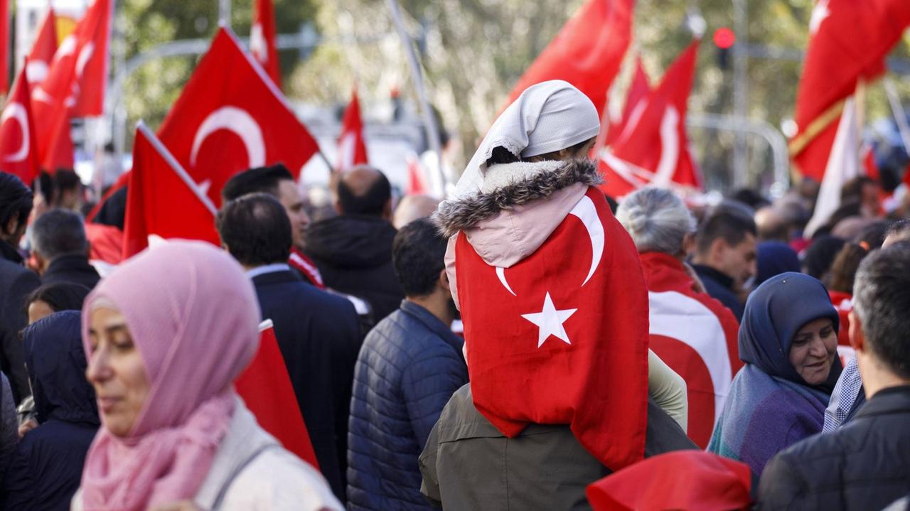 Menschen schwenken in der Öffentlichkeit türkische Staatsflaggen. Menschen schwenken in der Öffentlichkeit türkische Staatsflaggen.
