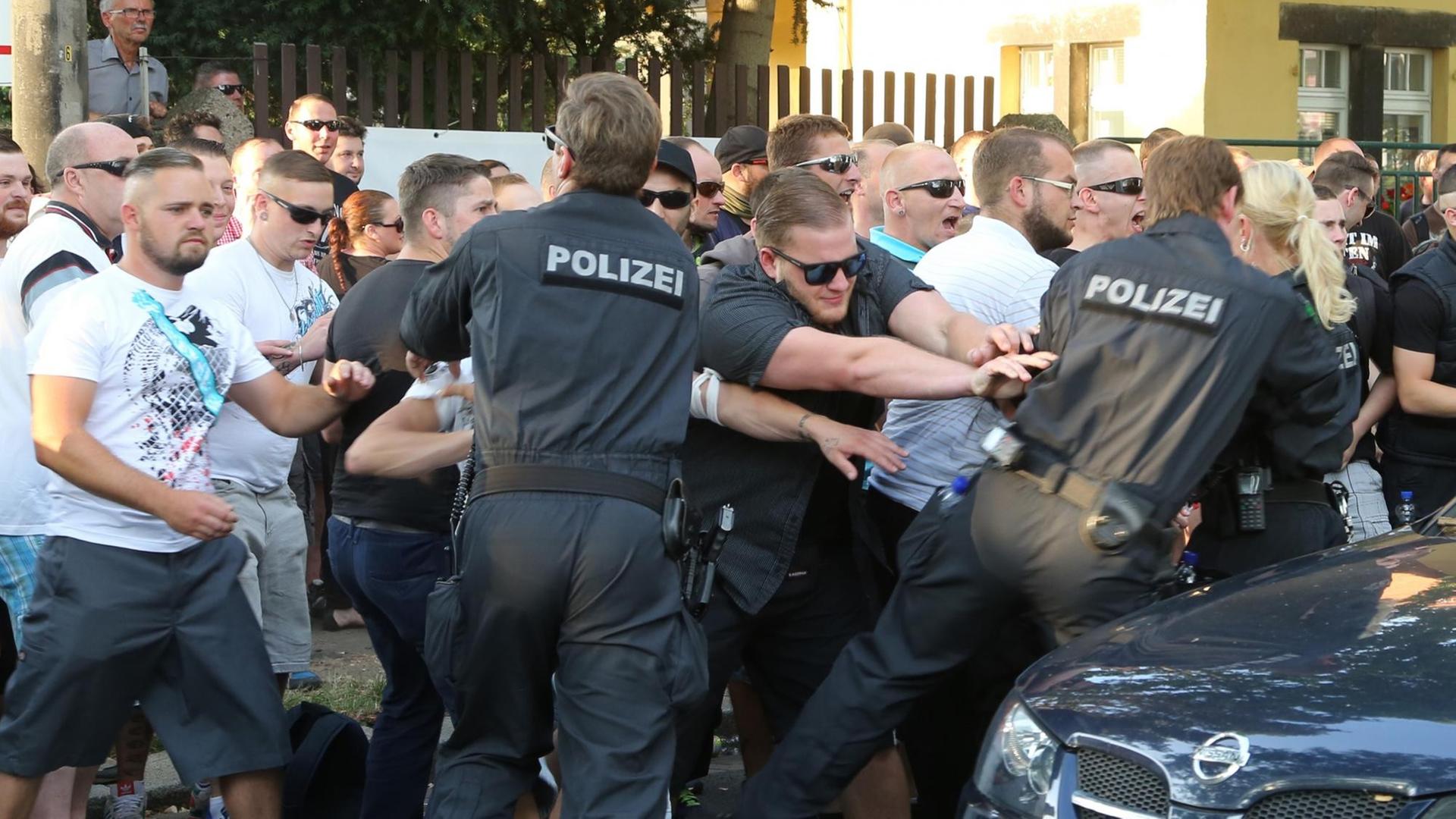 Teilnehmer einer NPD-Demonstration rangeln am 24.07.2015 in Dresden mit Polizeibeamten. Teilnehmer einer NPD-Demonstration rangeln am 24.07.2015 in Dresden mit Polizeibeamten.