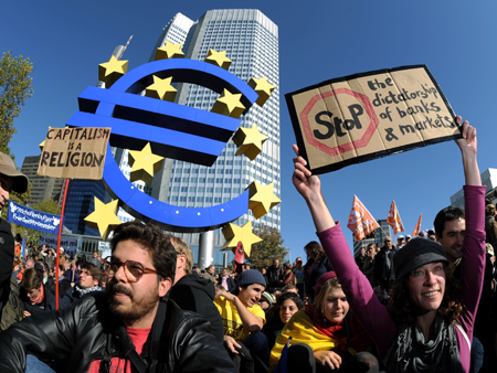 Demonstranten sitzen während einer Kundgebung vor der EZB in Frankfurt am Main. Demonstranten sitzen während einer Kundgebung vor der EZB in Frankfurt am Main.
