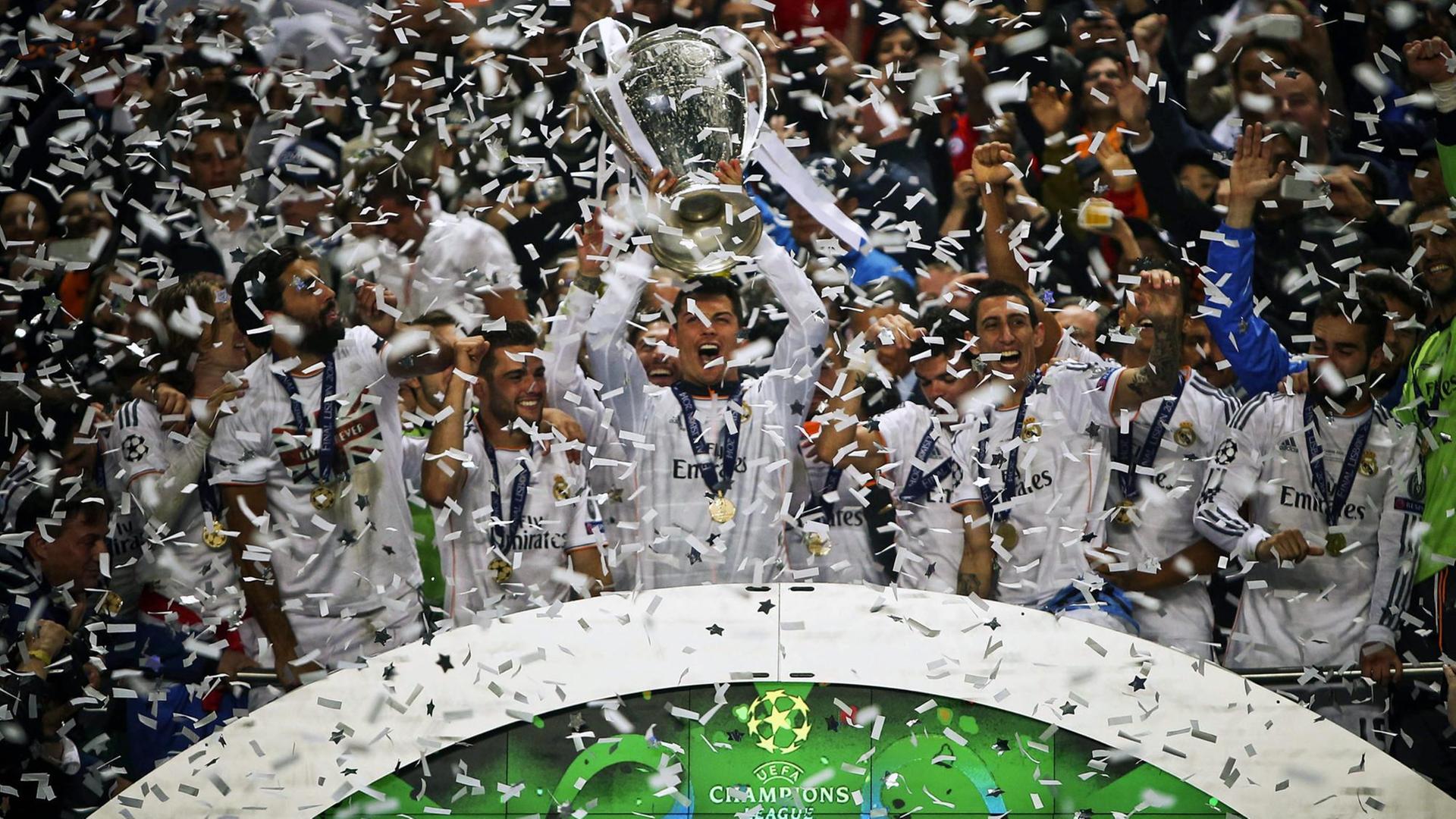 Nach dem Finale der Champions-League jubeln mehrere Fußballspieler und recken den Pokal in die Höhe