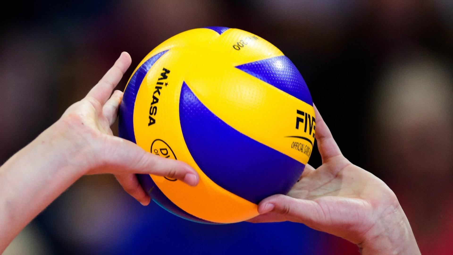 Großaufnahme: Zwei Hände pritschen einen Volleyball Großaufnahme: Zwei Hände pritschen einen Volleyball
