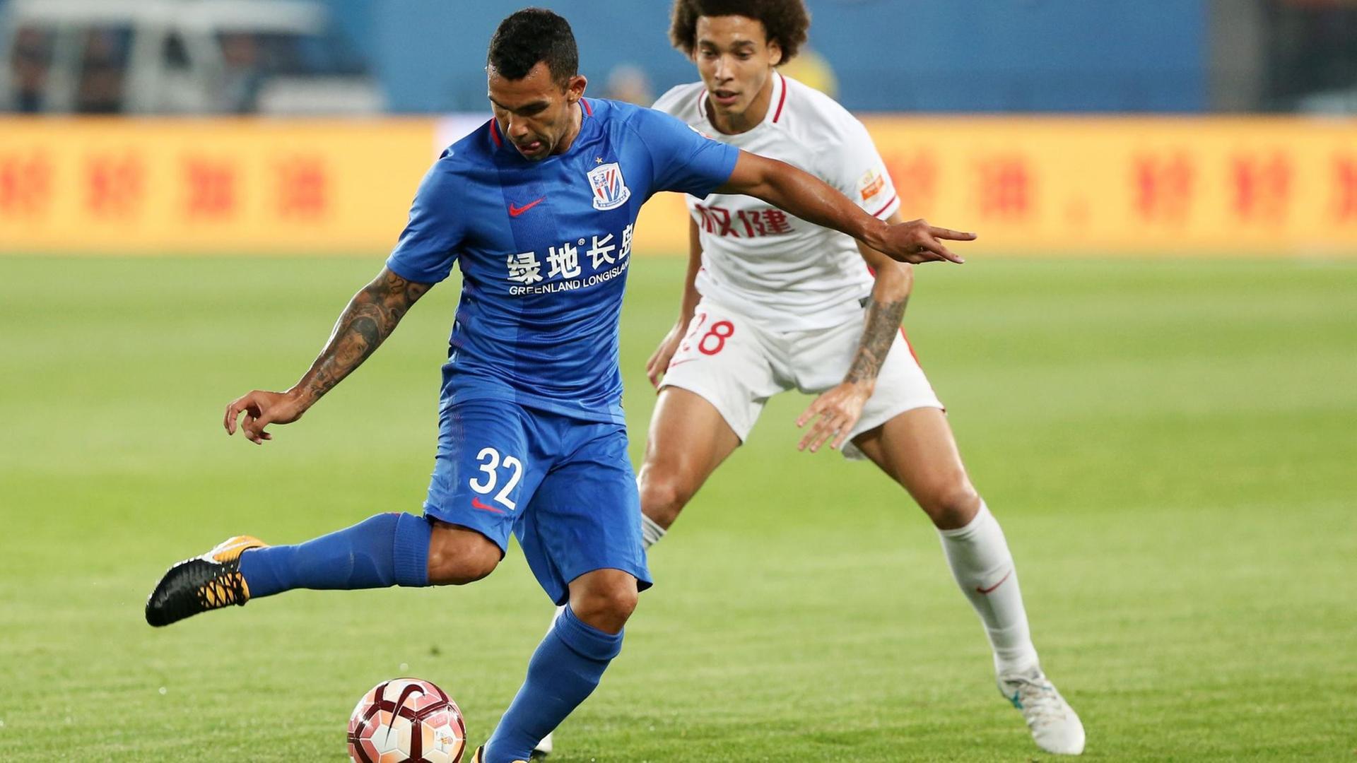 Carlos Tevez schirmt den Ball vor Axel Witsel ab Carlos Tevez schirmt den Ball vor Axel Witsel ab