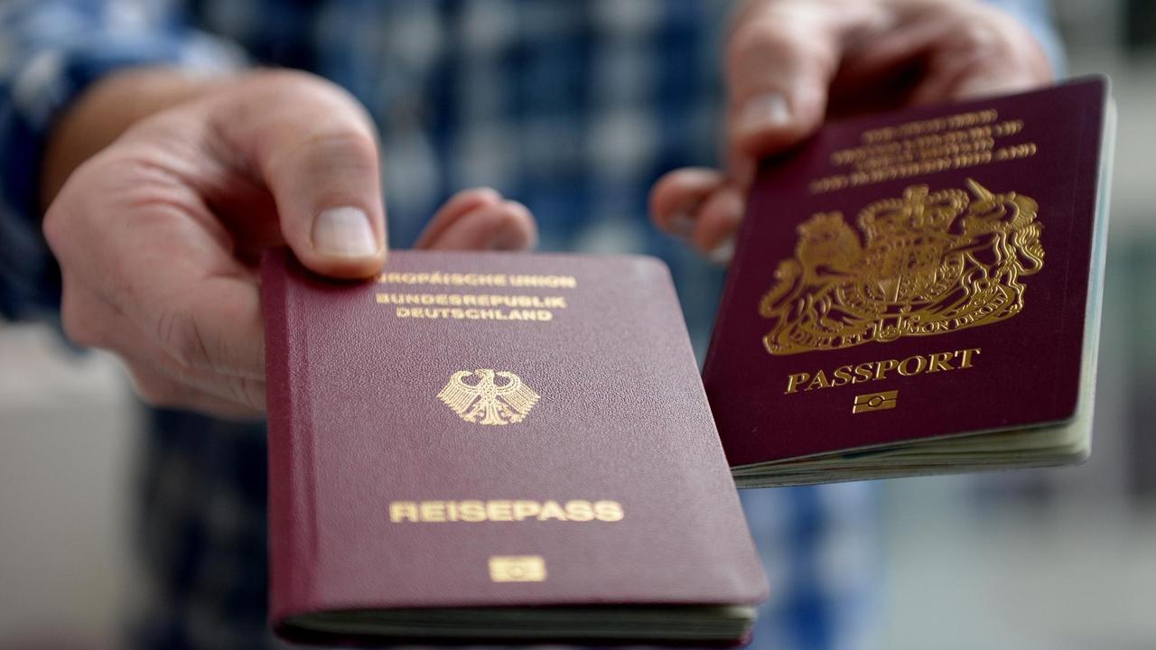Ein britischer und ein deutscher Reisepass, aufgenommen am 06.07.2016 in Berlin. Foto: Britta Pedersen/dpa (zu dpa «Nach dem Brexit: Mehr Berliner Briten wollen Deutsche werden») | Verwendung weltweit Ein britischer und ein deutscher Reisepass, aufgenommen am 06.07.2016 in Berlin. Foto: Britta Pedersen/dpa (zu dpa «Nach dem Brexit: Mehr Berliner Briten wollen Deutsche werden») | Verwendung weltweit