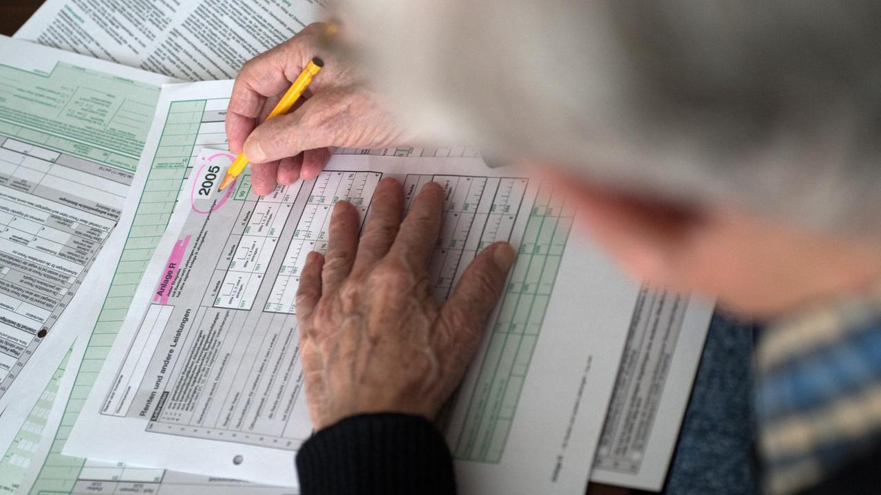 Ein Rentner ist vertieft in das Ausfüllen seiner Einkommensteuererklärung 2005. Für viele Senioren, nicht erst über 80, ist das Ausfüllen der Steuerformulare eine gewaltige Herausforderung. Ein Rentner ist vertieft in das Ausfüllen seiner Einkommensteuererklärung 2005. Für viele Senioren, nicht erst über 80, ist das Ausfüllen der Steuerformulare eine gewaltige Herausforderung.