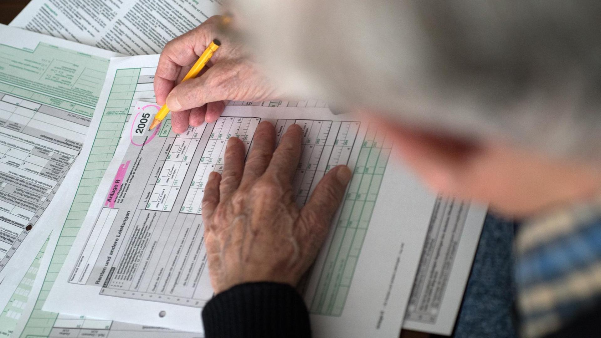 Ein Rentner ist vertieft in das Ausfüllen seiner Einkommensteuererklärung 2005. Für viele Senioren, nicht erst über 80, ist das Ausfüllen der Steuerformulare eine gewaltige Herausforderung. Ein Rentner ist vertieft in das Ausfüllen seiner Einkommensteuererklärung 2005. Für viele Senioren, nicht erst über 80, ist das Ausfüllen der Steuerformulare eine gewaltige Herausforderung.