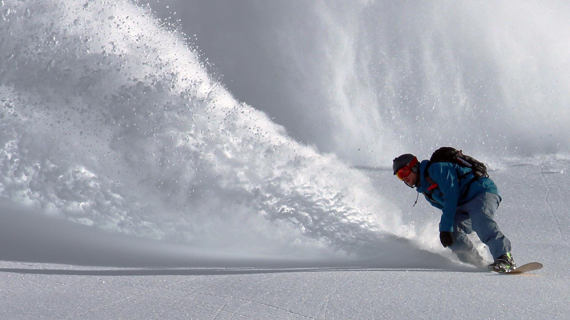 Ein Snowboardfahrer in einem Skigebiet. Ein Snowboardfahrer in einem Skigebiet.