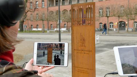 Eine Frau mit einem Tablet an einer der Stationen des interaktiven Denkmals "Remember" der Berliner Charité