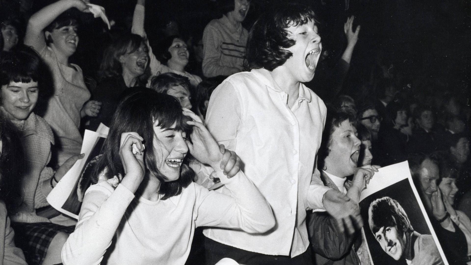 Schreiende, weibliche Beatles-Fans im April 1964 in London. Schreiende, weibliche Beatles-Fans im April 1964 in London.