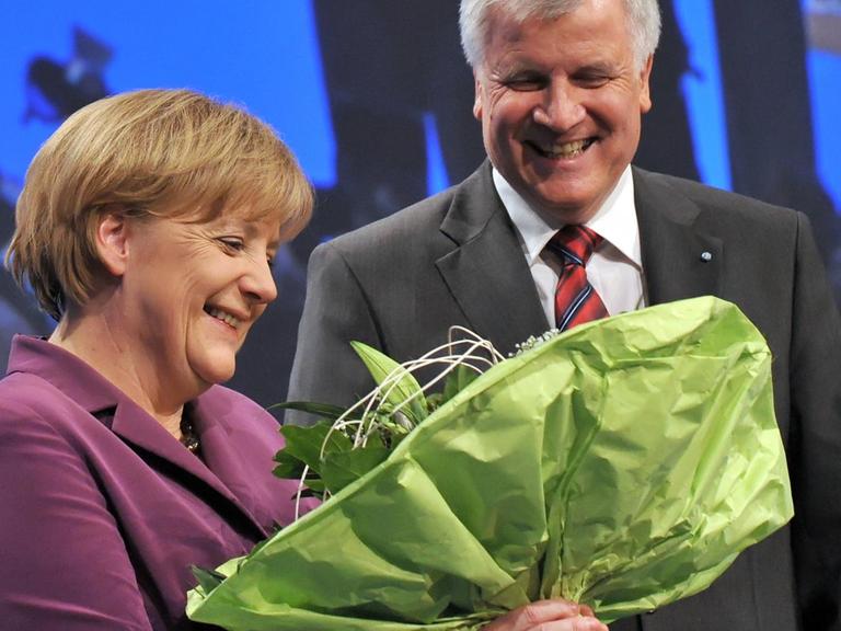 Die Bundeskanzlerin Angela Merkel (CDU) erhält am Freitag (29.10.2010) in München (Oberbayern) auf dem Parteitag der CSU nach ihrer Grußrede einen Blumenstrauß vom CSU-Parteivorsitzenden Horst Seehofer.