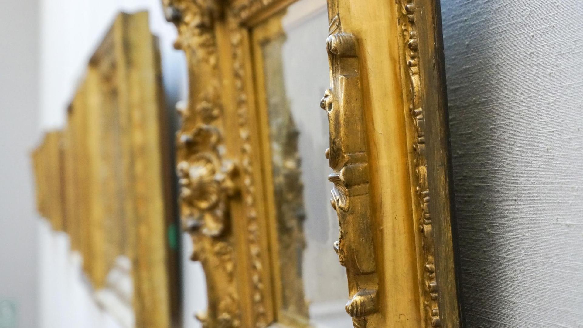 Goldene Bilderrahmen hängen an einer Wand. Goldene Bilderrahmen hängen an einer Wand.