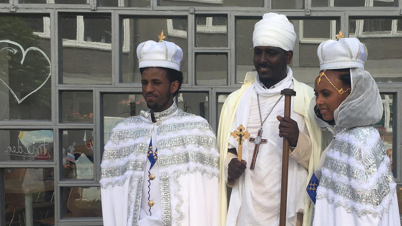 Das Brautpaar, hier vor der Kirche mit Pfarrer Msgun Tamzgi, trägt traditionelle Umhänge. Das Brautpaar, hier vor der Kirche mit Pfarrer Msgun Tamzgi, trägt traditionelle Umhänge.