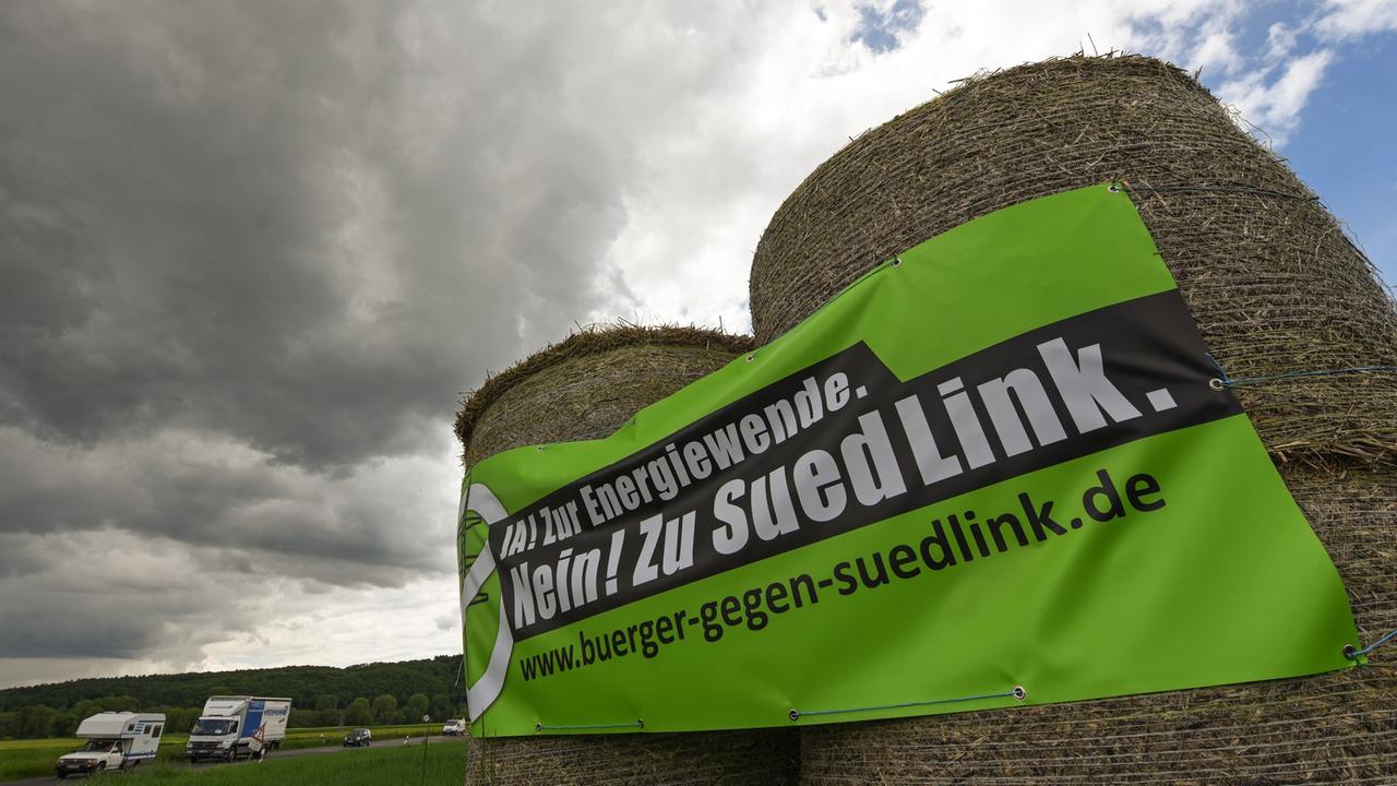 Auf Heuballen prangt am 20.05.2015 an einer Straße bei Fritzlar (Hessen) ein Transparent der Gegner der Stromtrasse Suedlink.