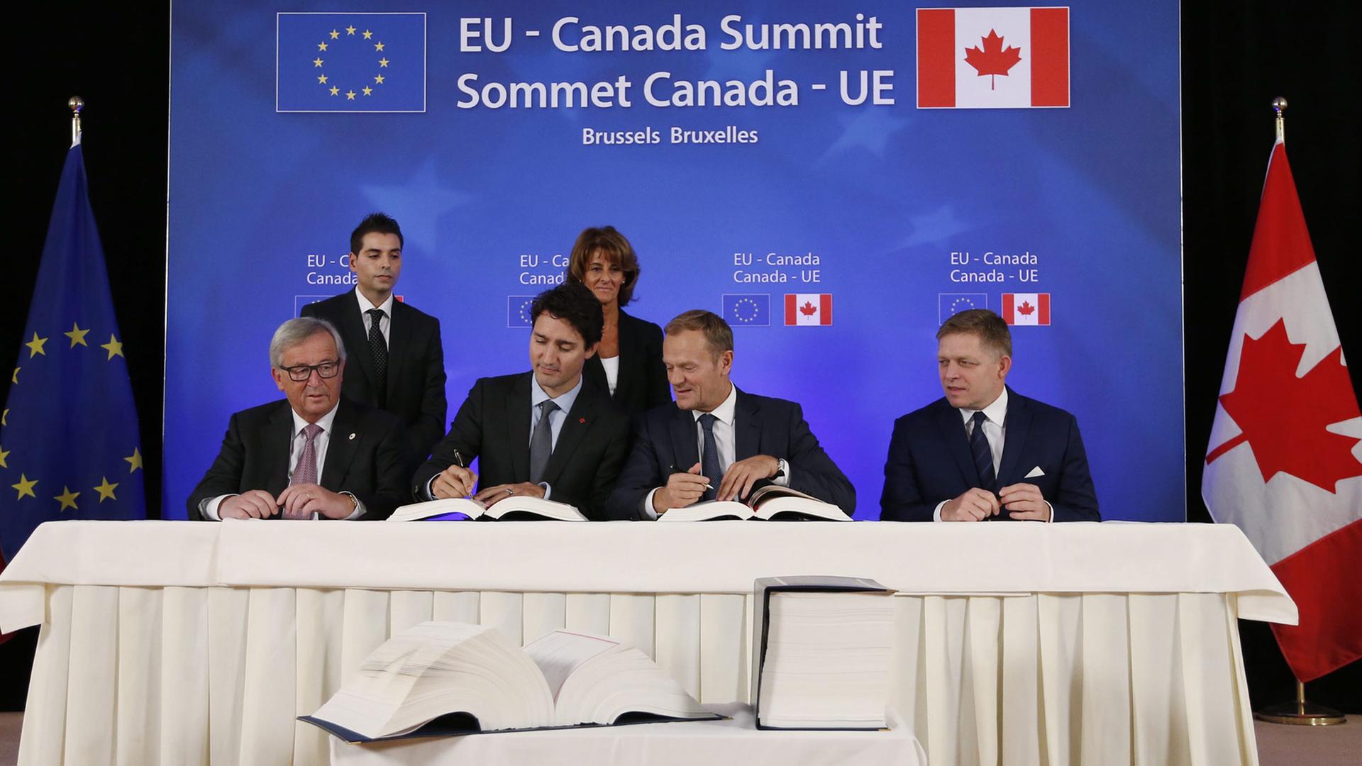 Das kanadisch-europäische Handelsabkommen Ceta wird unterzeichnet von EU-Kommissionspräsident Jean-Claude Juncker, Kanadas Premierminister Justin Trudeau, EU-Ratspräsident Donald Tusk und slowakische Regierungschef Robert Fico (v.l.n.r.)