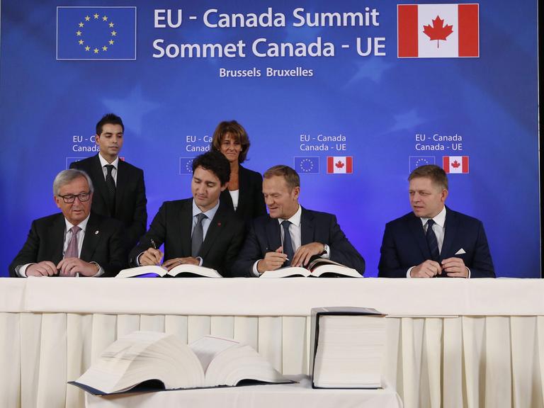 Das kanadisch-europäische Handelsabkommen Ceta wird unterzeichnet von EU-Kommissionspräsident Jean-Claude Juncker, Kanadas Premierminister Justin Trudeau, EU-Ratspräsident Donald Tusk und slowakische Regierungschef Robert Fico (v.l.n.r.)
