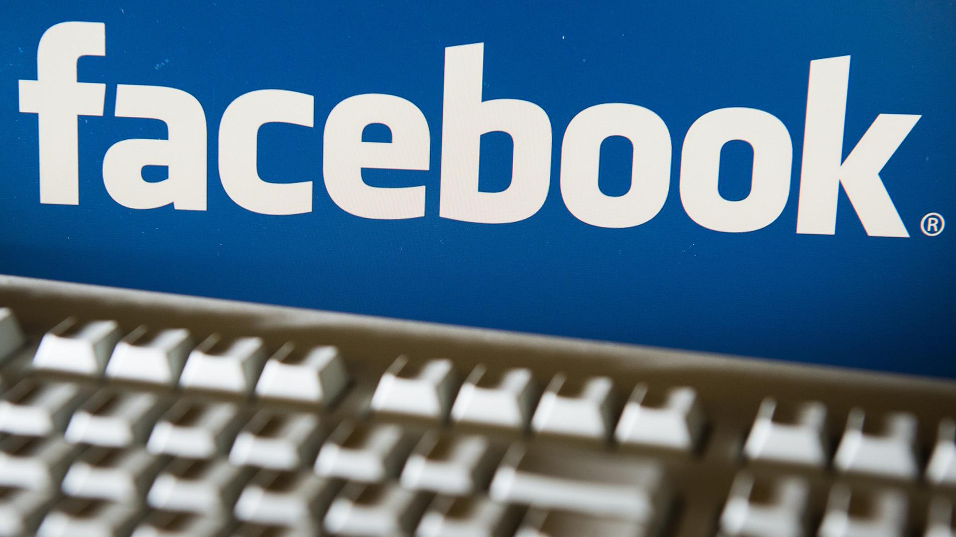 Das Logo von Facebook ist auf einem Bildschirm zusammen mit einer Tastatur zu sehen. Das Logo von Facebook ist auf einem Bildschirm zusammen mit einer Tastatur zu sehen.