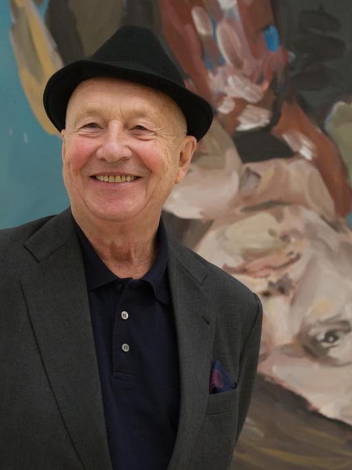 Der Künstler Georg Baselitz steht vor einem Porträt seiner Frau.