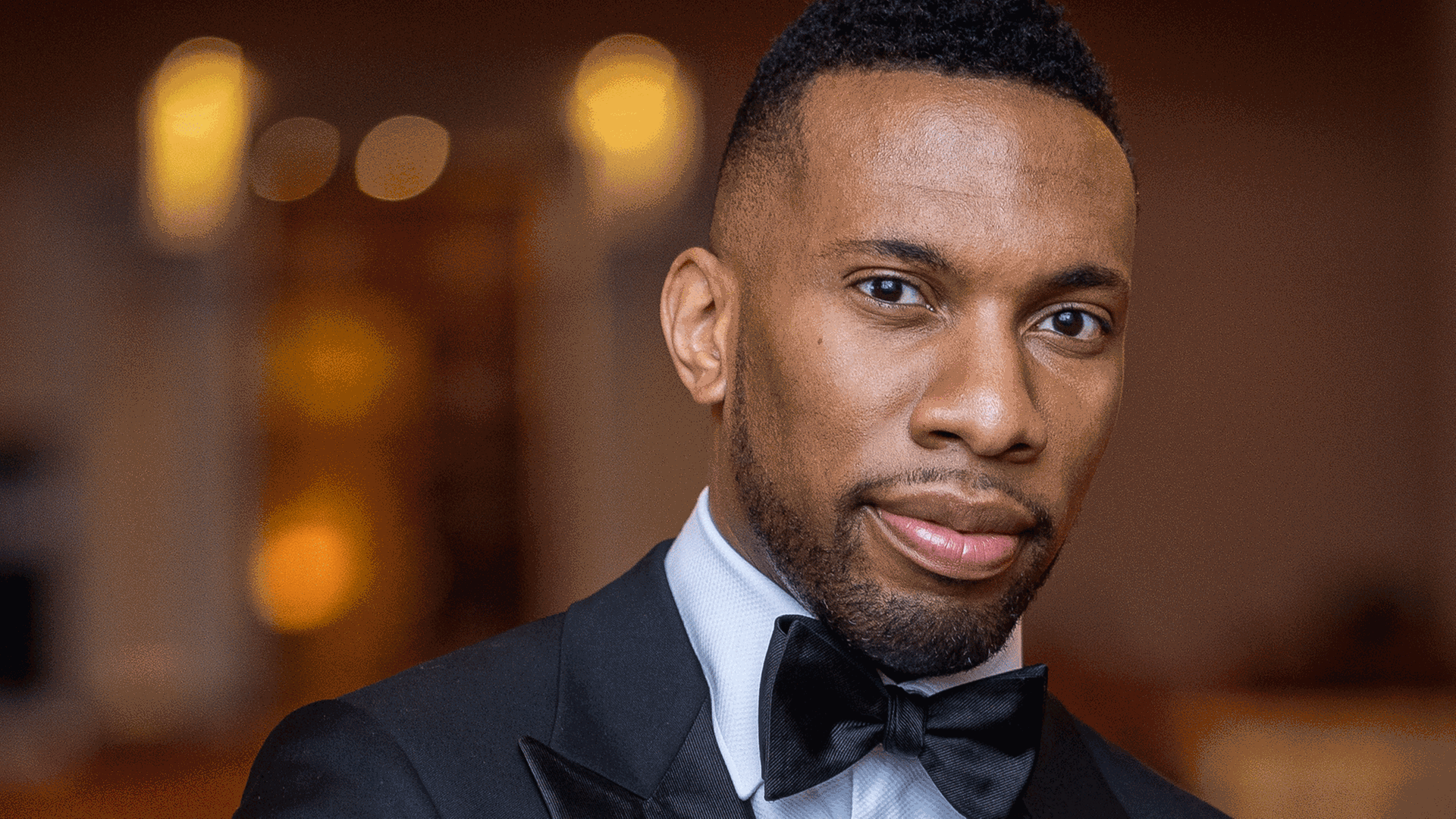 Der Dirigent Roderick Cox blickt in Konzertkleidung in die Kamera. Der Dirigent Roderick Cox blickt in Konzertkleidung in die Kamera.