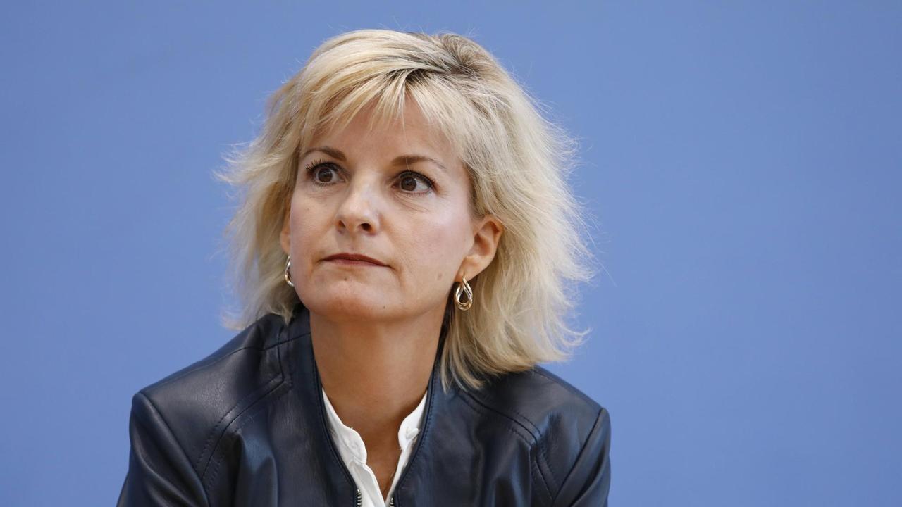 Porträtfoto von Daniela Ludwig, mit halblangen blonden Haaren und dunkler Jacke vor blauem Hintergrund. Porträtfoto von Daniela Ludwig, mit halblangen blonden Haaren und dunkler Jacke vor blauem Hintergrund.
