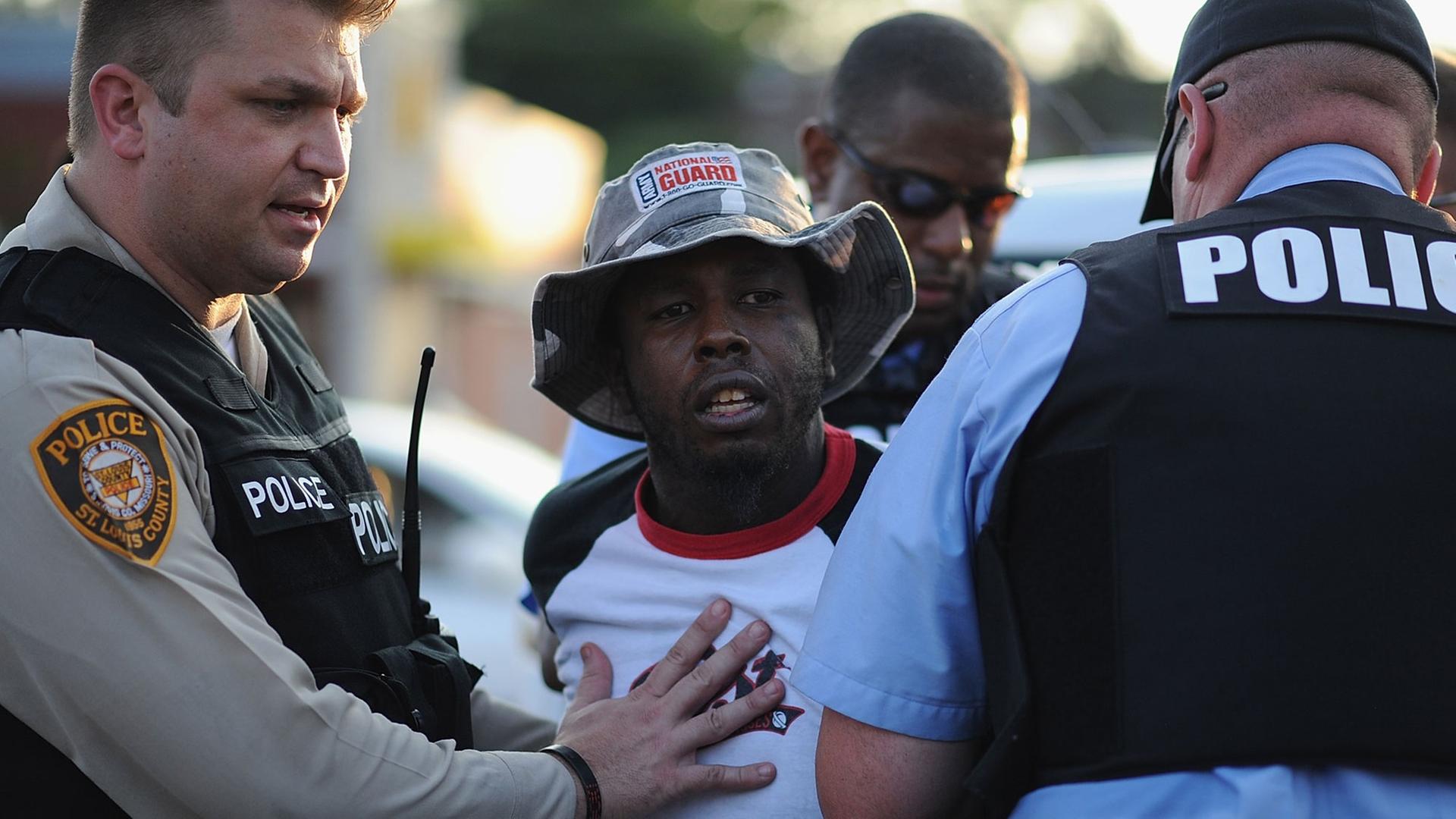 In der US-Kleinstadt Ferguson nimmt die die Polizei einen schwarzen Demonstranten fest. In der US-Kleinstadt Ferguson nimmt die die Polizei einen schwarzen Demonstranten fest.