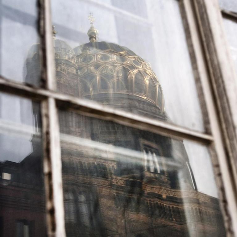 Die Synagoge in der Oranienburger Strasse in Berlin, spiegelt sich in einem gegenueberliegenden Fenster.
